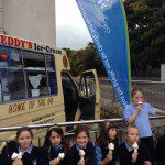 St Annes kids with ice cream 3 sitting on wall with CU flag