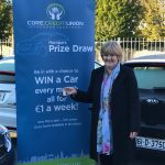 Winner Elaine Cowzer with car keys and banner up close