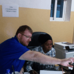 Caption 2. Michael providing support to Haddy staff member of Gambia Revenue Authority Cooperative Credit Union.