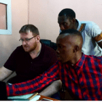 Caption 3. Michael reviewing accounts of Soforoa Cooperative Credit Union with Bakary Bojang, Manager.